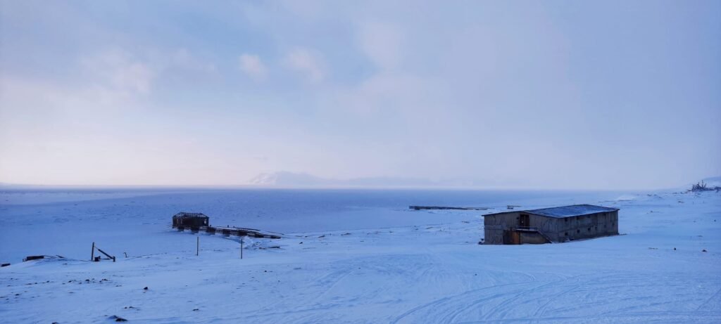 oud gebouw naast dicht gevroren zee in Spitsbergen