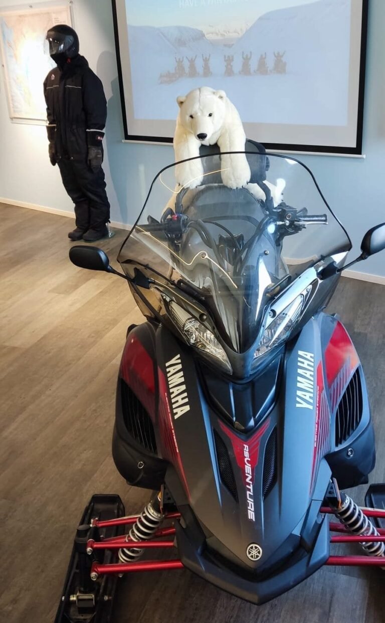 een sneeuwscooter binnen om uit te leggen hoe je er mee moet rijden tijdens een excursie in Spitsbergen