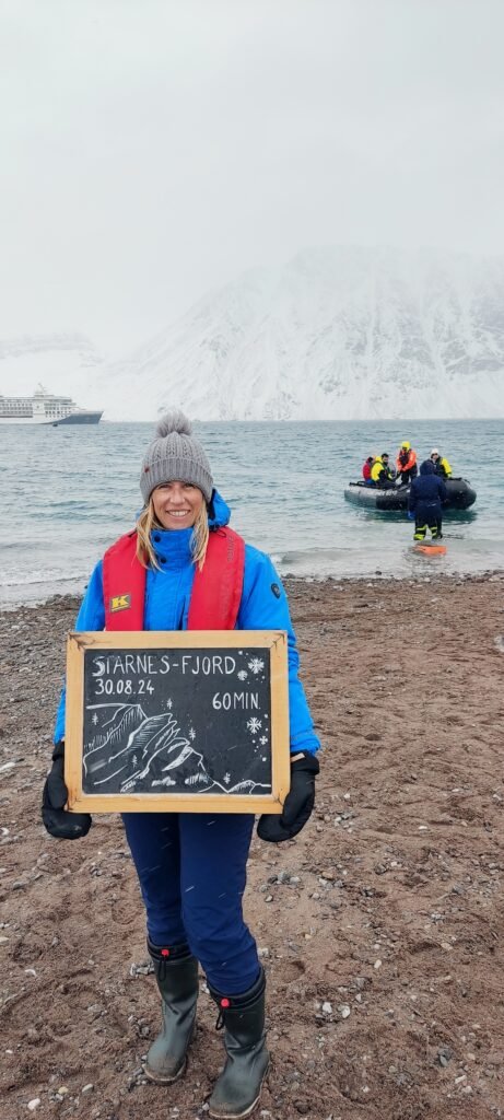 vrouw met muts tijdens cruise met Hapag Lloyd in Starnes fjord Groenland met op de achtergrond het expeditieschip en zodiac