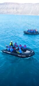 zodiacs in het water met mensen in met op de achtergrond hoge bergen in Groenland-cruise-Hapag-Lloyd