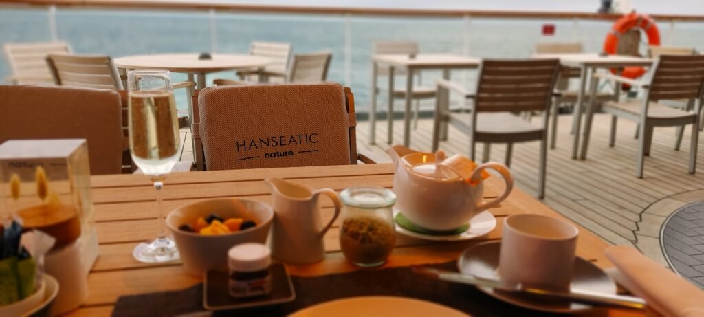 Ontbijt buiten met koffie op achterdek van Hanseatic Nature Hapag Lloyd tijdens een cruise naar Groenland